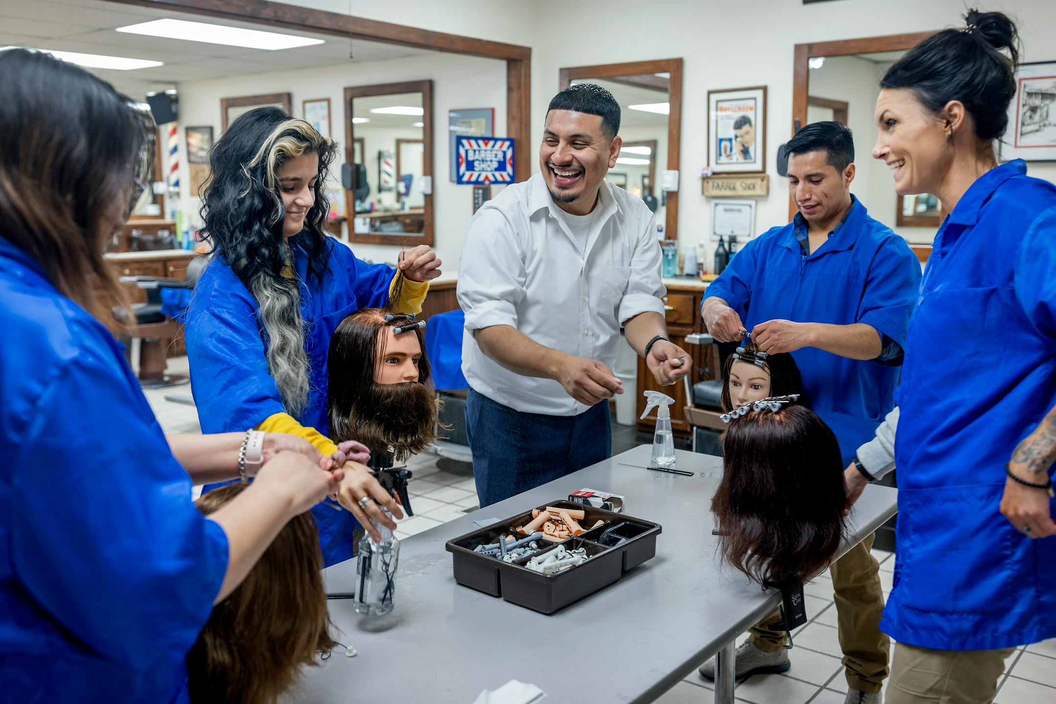 Barber Lamberto Vergara guided students on how to roll hair at the Minnesota School of Barbering in Minneapolis. Vergara purchased the school after riots destroyed the area where he had his barbershop.