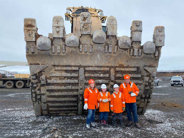 Aimee, Delphine, Julien and Nathan Munson stood in front of the bucket of an excavator at the Keetac mine during a tour in April.