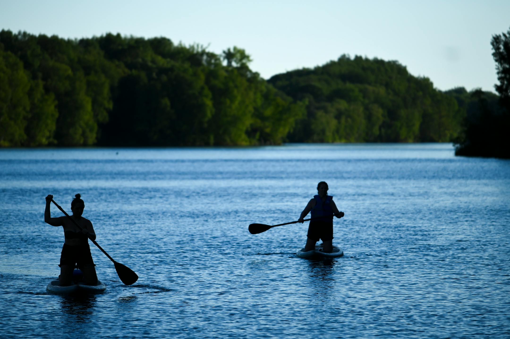 Lindsey Kielty, left, and her mother, Chrissy Kielty, of Excelsior, paddled back to shore after an evening paddle-board ride on Huntington-Feigh Mine Lake Monday night.