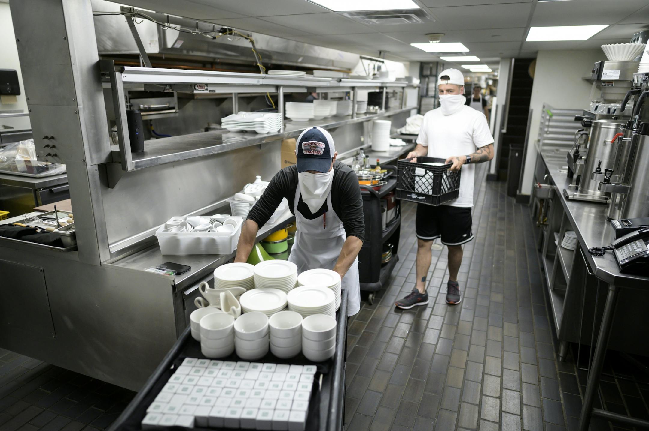 Andres Espinoza, an employee at Fhima's, and operations manager Eli Fhima, back right, worked on emptying the kitchen of all items before a deep cleaning and sanitizing. aaron.lavinsky@startribune.com Restaurants react to Gov. Walz's reopening order whatever it is. We photograph Fhima's as workers prepare for possible reopening on Wednesday, May 20, 2020 in Minneapolis, Minn.