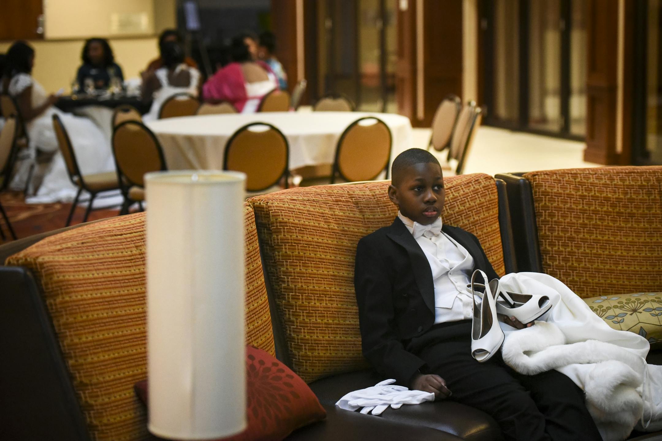 Robert Tisdale, 9, held his sister Robyn's shoes, gloves and cape before Saturday's cotillion.