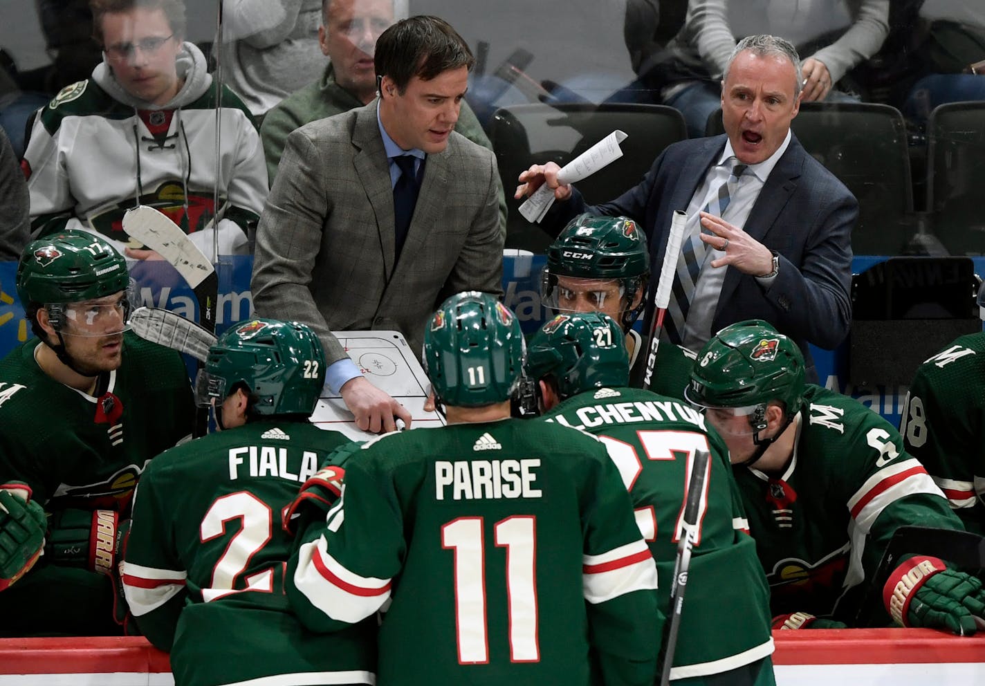 Wild interim head coach Dean Evason, right, speaks to his players along with assistant coach Darby Hendrickson on March 1.