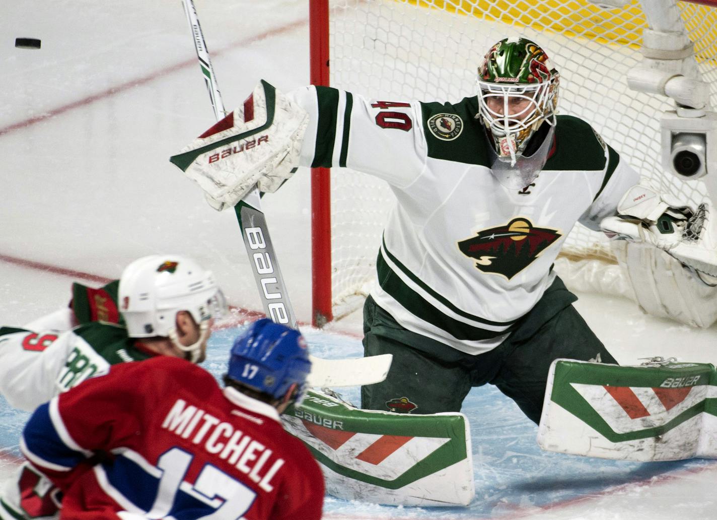 Minnesota Wild's goalie Devan Dubnyk makes a save as Montreal Canadiens' Torrey Mitchell (17) and the Wild's Nate Prosser look for the rebound during the second period of an NHL hockey game in Montreal on Saturday, March 12, 2016. (Graham Hughes /The Canadian Press via AP) MANDATORY CREDIT