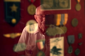 Vern Luettinger, 96, was a radio man on the USS California at Pearl Harbor on Dec. 7, 1941. Here, Vern is reflected in a framed collection of medals a