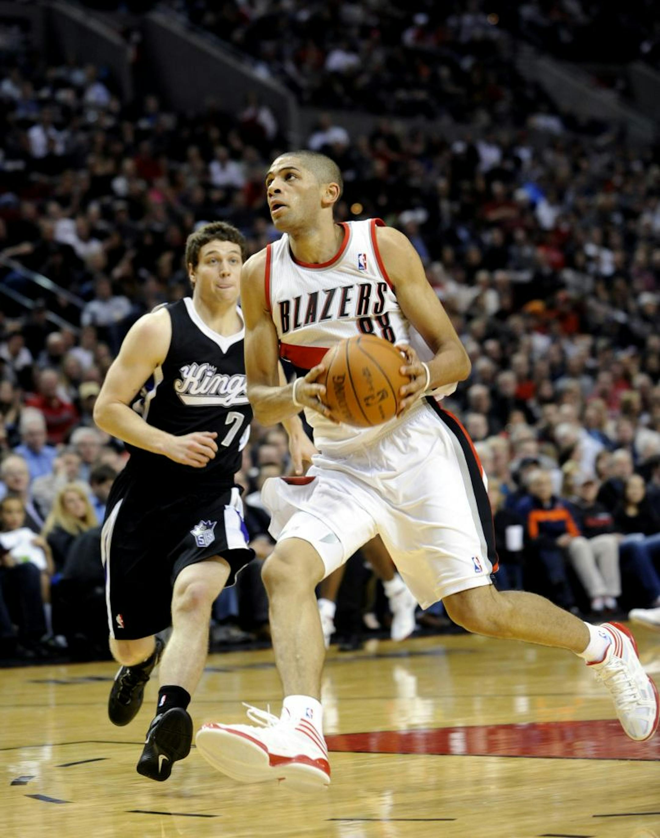 Sacramento Kings' Jimmer Fredette (7) defends a drive by Portland Trail Blazers' Nicolas Batum (88) from France during an NBA basketball game in Portland, Ore., Tuesday, Dec. 27, 2011.