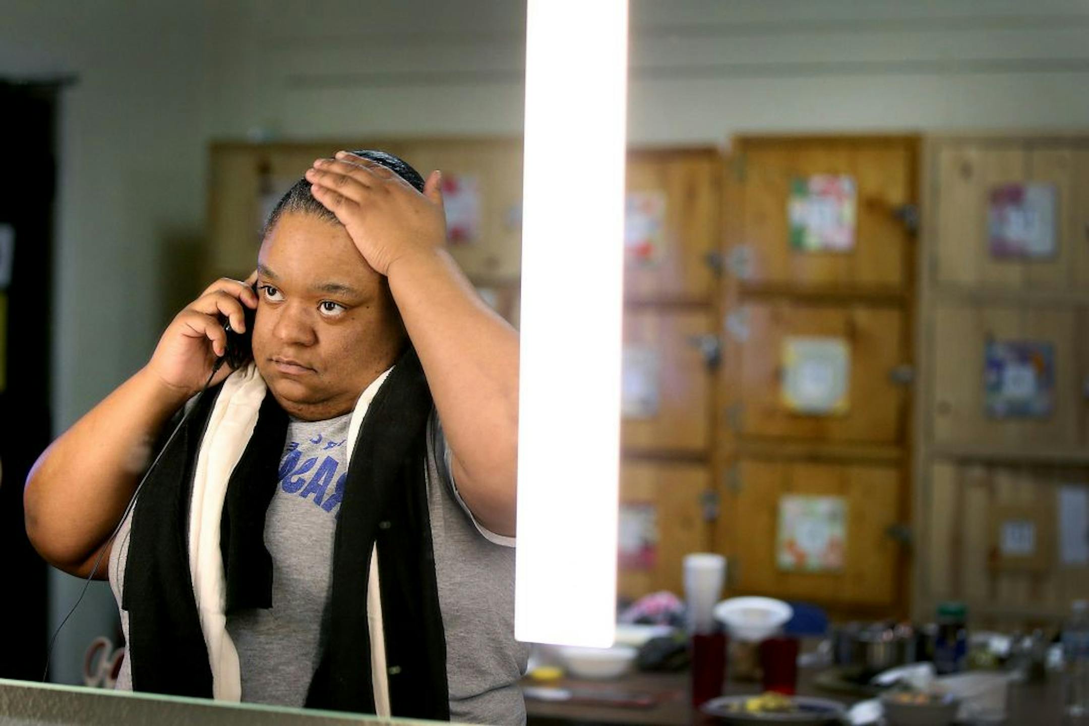 Mandisha Kelley fixed her hair while on the phone in the women's section of the Simpson Housing Shelter, Friday, February 12, 2016 in Minneapolis, MN.