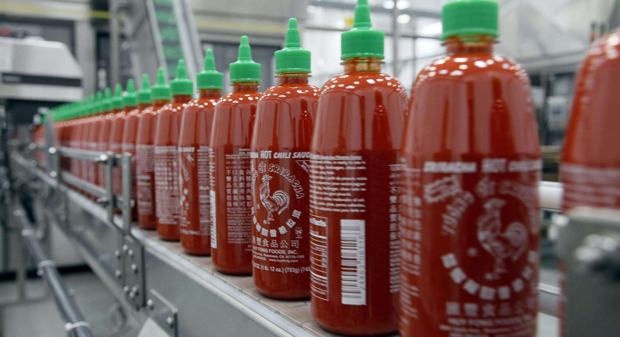 FILE - In the Tuesday, Oct. 29, 2013, file photo, Sriracha chili sauce is produced at the Huy Fong Foods factory in Irwindale, Calif. The Irwindale City Council voted Wednesday May 28, 2014 night to drop a public nuisance declaration and lawsuit against Huy Fong Foods, makers of Sriracha hot sauce. (AP Photo/Nick Ut, File)