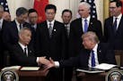 President Donald Trump shakes hands with Chinese Vice Premier Liu He, after signing a trade agreement in the East Room of the White House, Wednesday, 