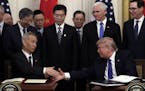 President Donald Trump shakes hands with Chinese Vice Premier Liu He, after signing a trade agreement in the East Room of the White House, Wednesday, 