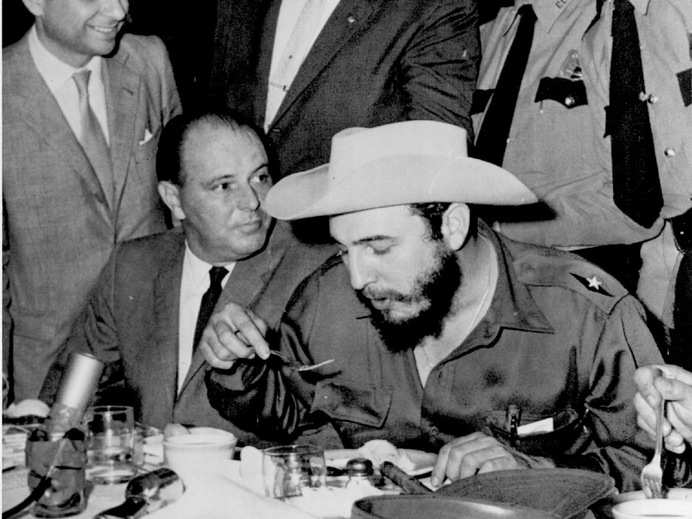 April 27, 1959 Eats Under Guard -- Cuba's Premier Fidel Castro, has a hurried meal under watchful eyes of Houston police after his arrival here today. Castro wore his gift hat from the time it was presented to him. Castro plans to spend the night in Houston and leave tomorrow. April 28, 1959 AP Wirephoto ORG XMIT: MIN2017012907501194