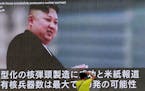 A man takes a photo of a TV news program in Tokyo, showing an image of North Korean leader Kim Jong Un Wednesday, Aug. 9, 2017. In an exchange of thre