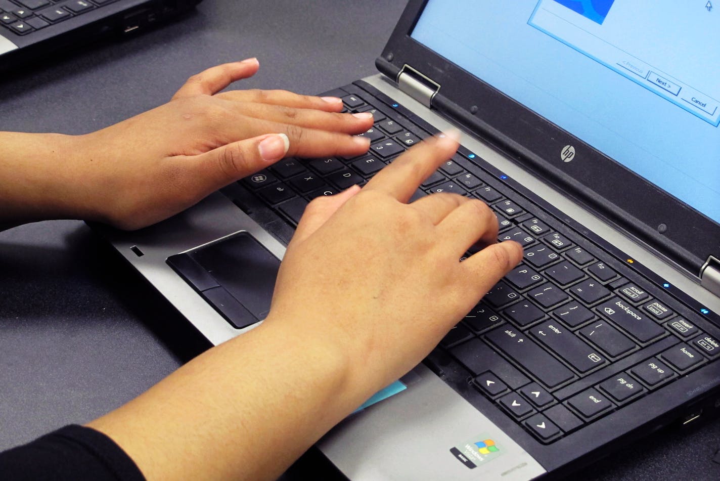 In this March 13, 2019, photo. a Bennett High School student re-images a laptop in a school computer lab in Buffalo, N.Y. The Buffalo district and others around the country are increasingly training students to help with the upkeep of thousands of laptops and iPads distributed to students in 1:1 initiatives that give students their own devices for the year. (AP Photo/Carolyn Thompson)