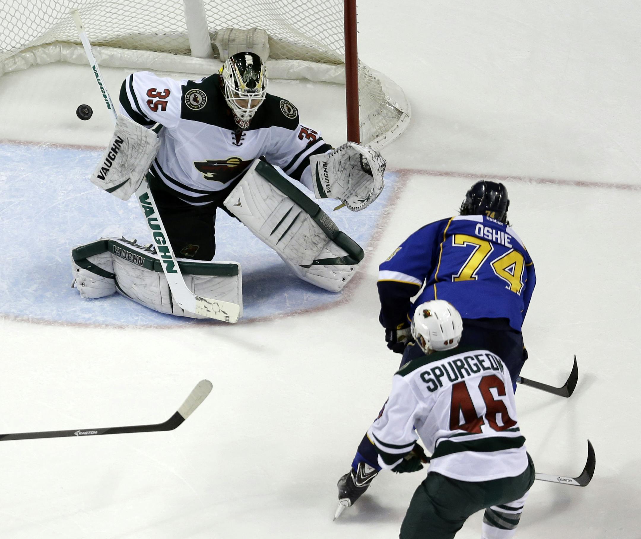 St. Louis Blues' T.J. Oshie (74) scores a short-handed goal past Minnesota Wild goalie Darcy Kuemper (35) as Wild's Jared Spurgeon watches during the first period of an NHL hockey game Thursday, March 27, 2014, in St. Louis. (AP Photo/Jeff Roberson)