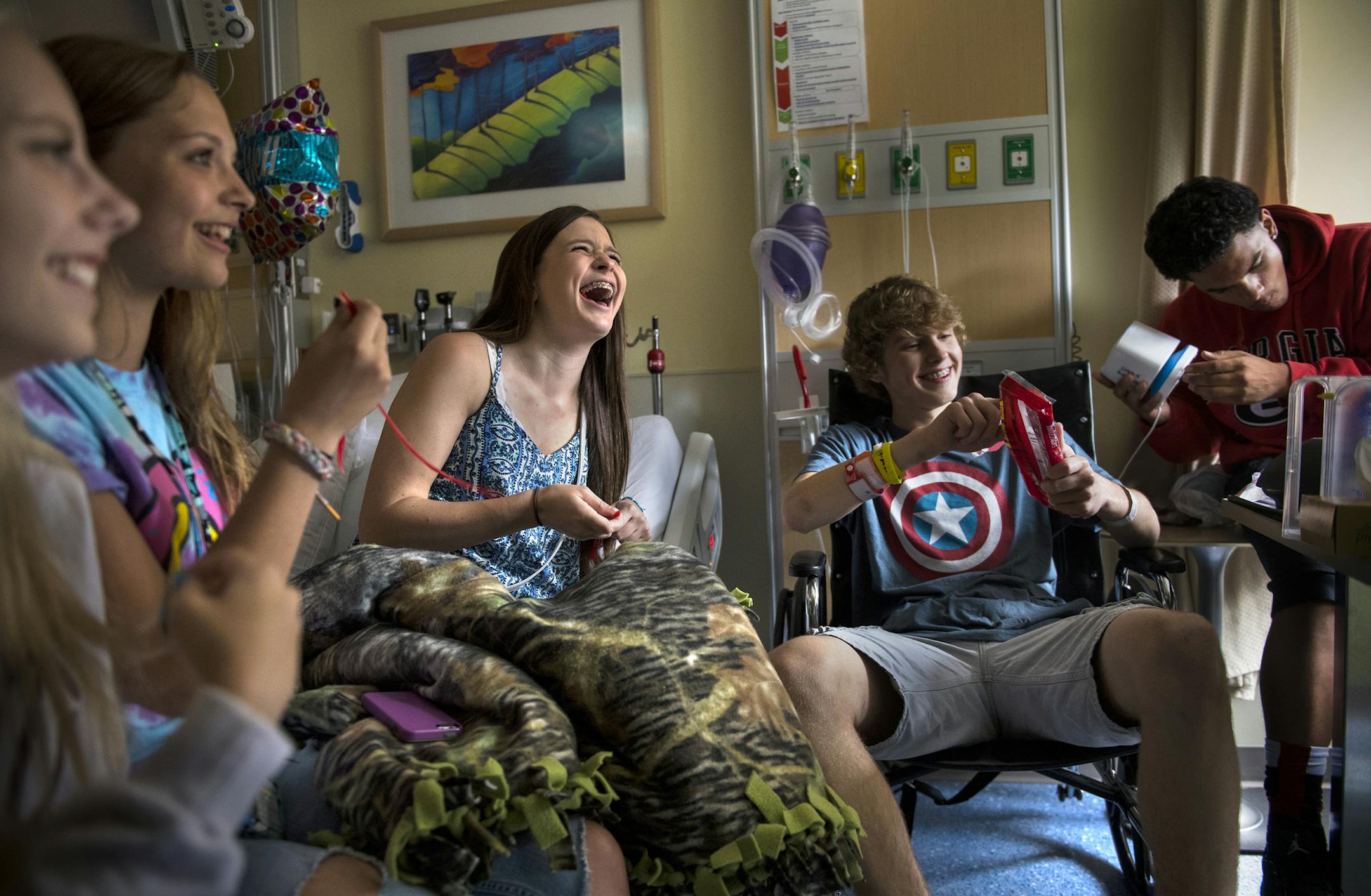 Daniel Fleigle, second from right, joked as he shared Twizzlers with his friends in his hospital room after a press conference held at the hospital on Monday. ] Isaac Hale ï isaac.hale@startribune.com Daniel Fleigle and his family held a press conference Monday, June 27, 2016, at the HCMC Emergency Department in downtown Minneapolis, MN. Fleigle was climbing atop a long-closed Mississippi River Bridge earlier in June when he was shocked by an electrical wire and fell about 30 feet. ORG XMIT
