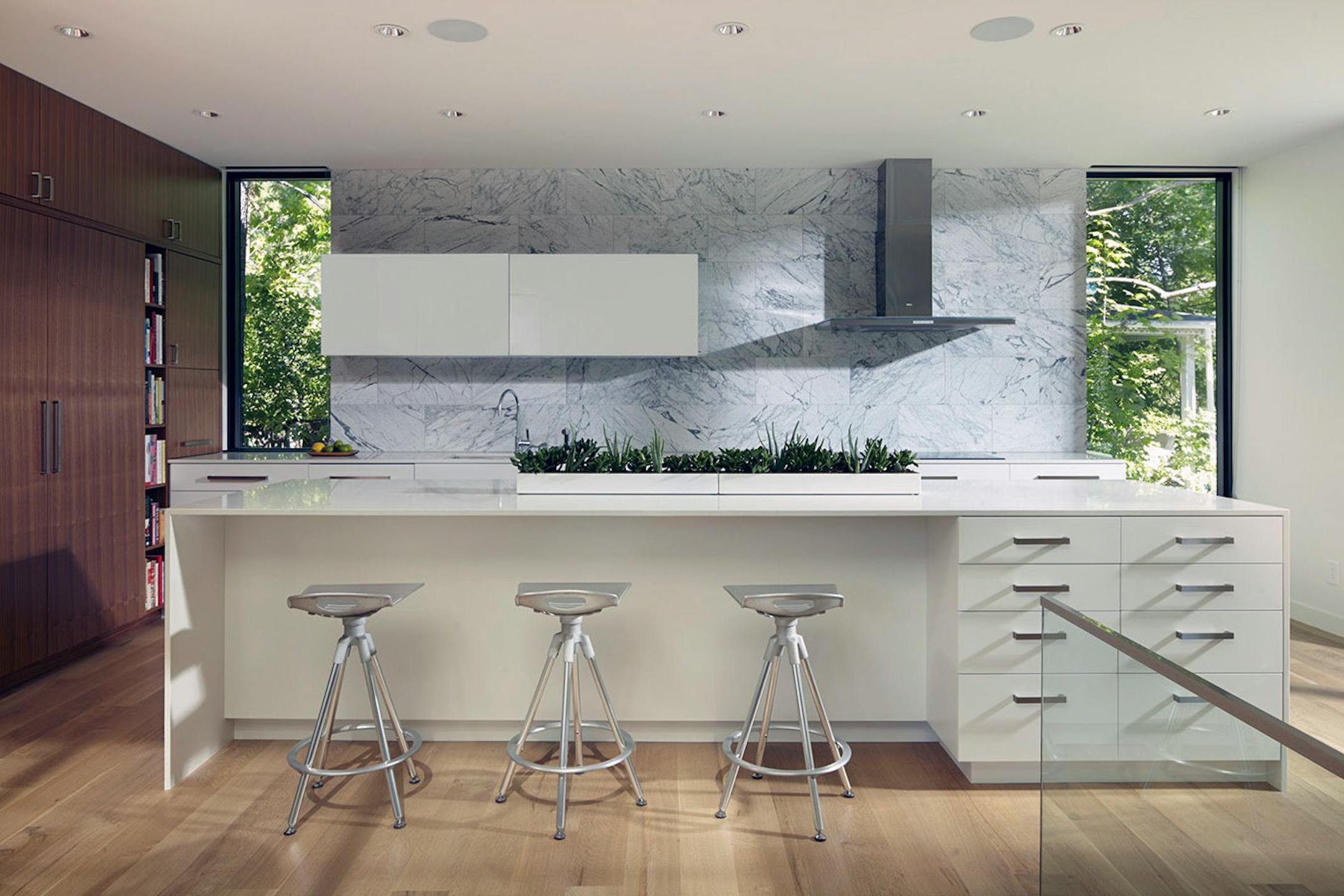 In the kitchen, swirly Carrara marble backsplash above crisp white Zodiaq quartz counters.