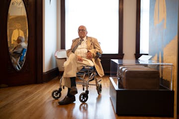 Benno Black sits near a photo of him as a boy and the suitcase his mother packed for him before he departed Germany in the kindertransport effort. The