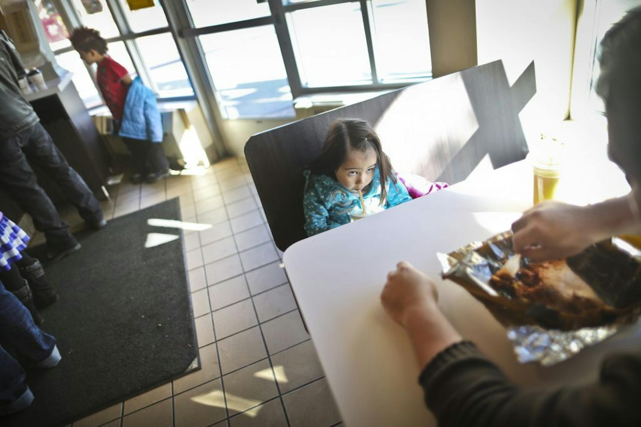 Scarlett Mendez drank a smoothie with her dad, Ulises Mendez, at Mercado Central in Minneapolis. The market is bustling, but the merchants are at odds.