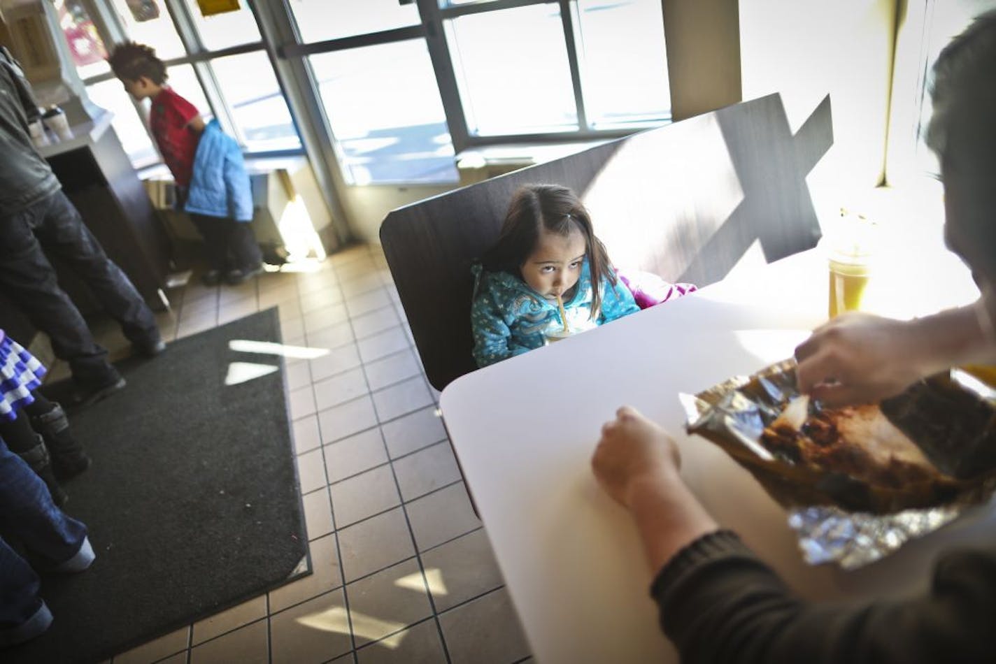 Scarlett Mendez drank a smoothie with her dad, Ulises Mendez, at Mercado Central in Minneapolis. The market is bustling, but the merchants are at odds.