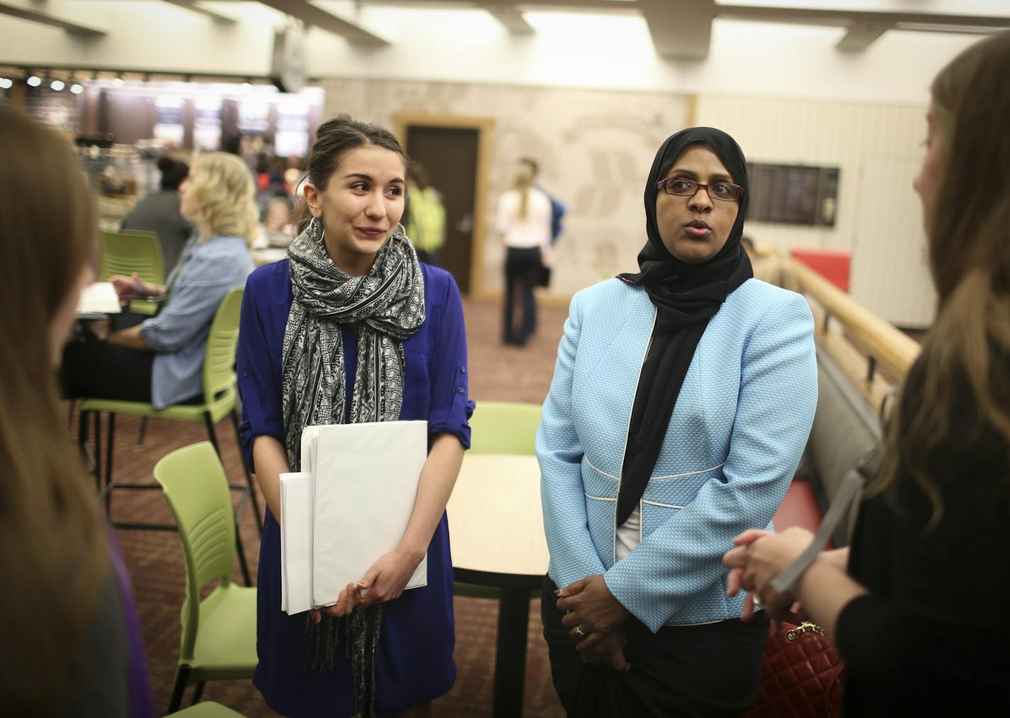 Fartun Weli, right, met with a group of women at a coffee shop before they walked her over to a lecture room where she gave a presentation on female genital cutting at a brown bag seminar for University of Minnesota medical students on Thursday, April 2, 2015 at the University of Minnesota in Minneapolis, Minn. At left is volunteer Hannah Aho. ] RENEE JONES SCHNEIDER &#x2022; reneejones@startribune.com