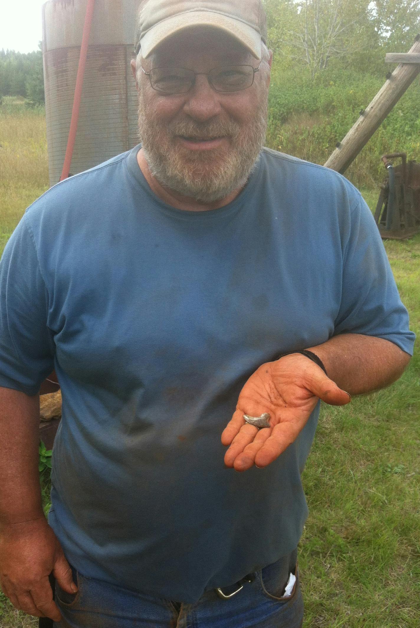 PHOTO BY MARK RYAN. Len Jannusch, a field crew volunteer with the Minnesota Science Museum&#xed;s paleontology project, discovered the dinosaur claw near a deer trail at Hill Annex Mine State Park on Aug. 17.