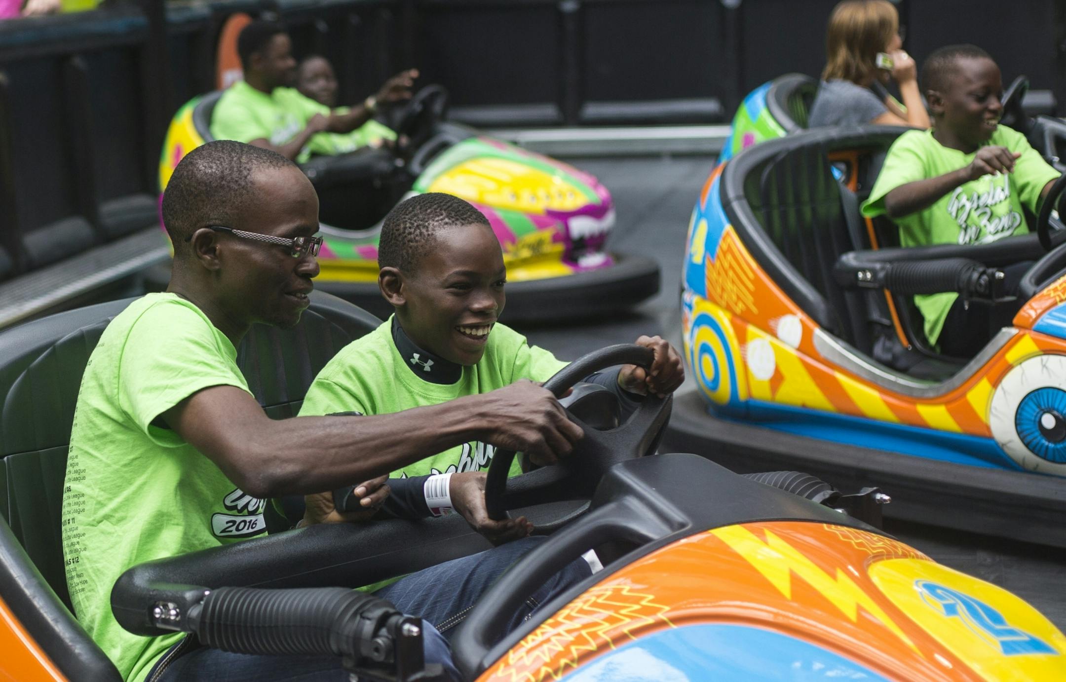 Vibel Aboue, center, drives a bumper car with help from coach Arnaud Adodo at the Nickelodeon Universe theme park at the Mall of America on Monday, August 1, 2016 in Bloomington, Minnesota.