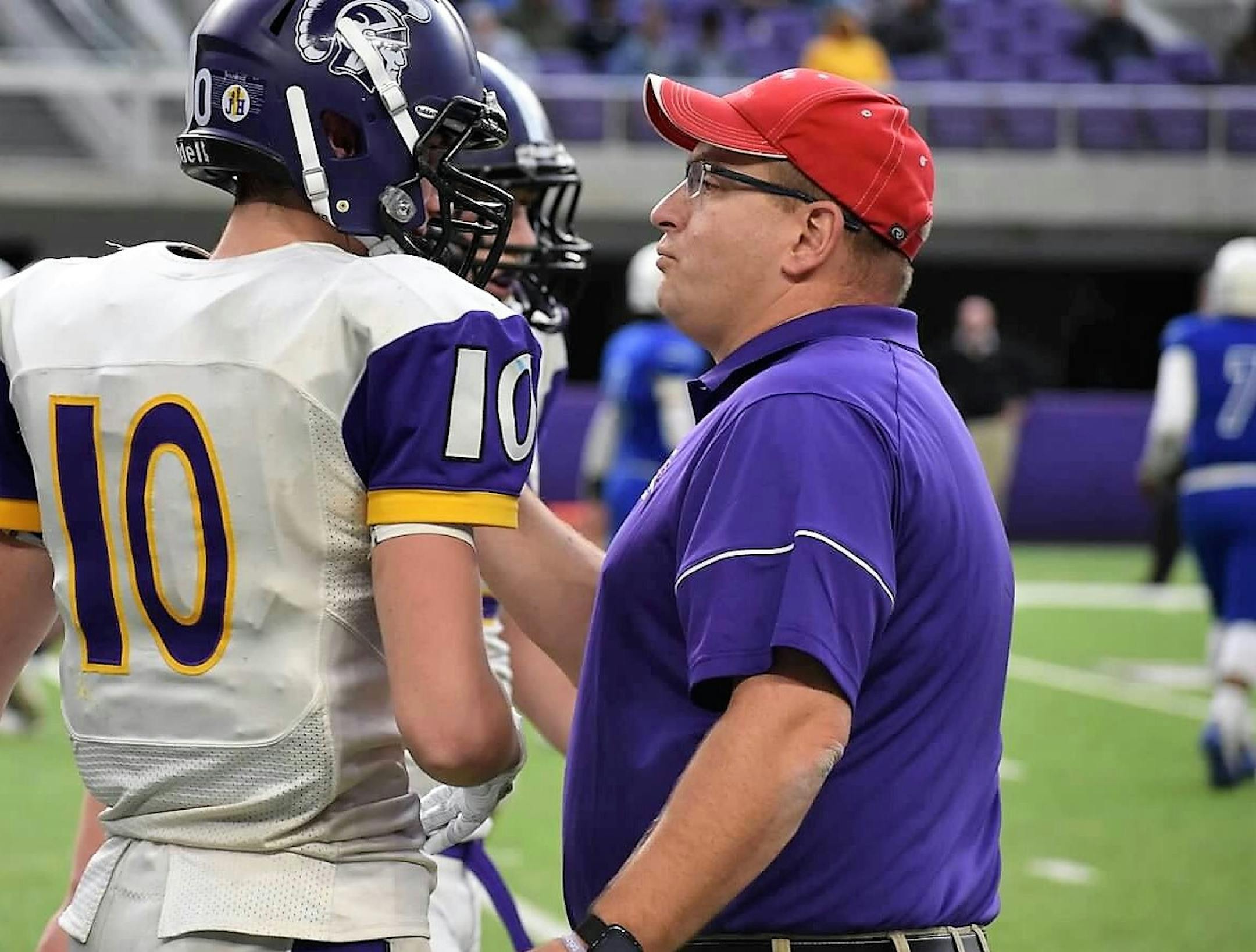 Barnesville coach Bryan Strand gives instructions to one of his players, Kellen Hinsz, during the Trojans' 34-20 victory over Minneapolis North in the Class 2A semifinals