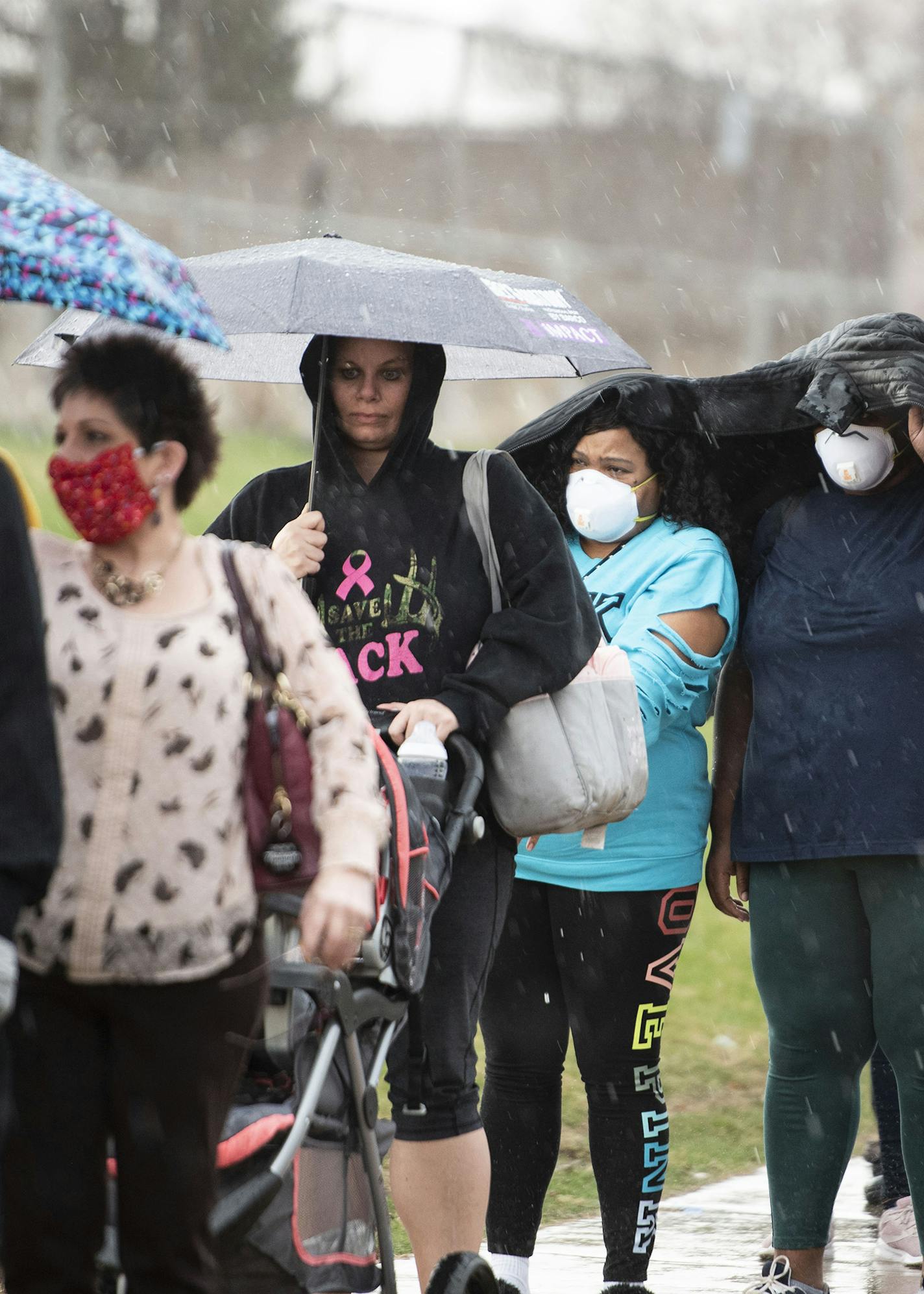 Rain falls on people waiting in line to vote at Milwaukee Marshall High School in Milwaukee, Tuesday, April 7, 2020. After Wisconsin scrambled to expand its vote-by-mail operation on the fly to accommodate voters who feared going to the polls on Tuesday, the cracks in the system are now emerging, the result of an election network and a Postal Service pushed to the brink of their capabilities. (Lauren Justice/The New York Times)