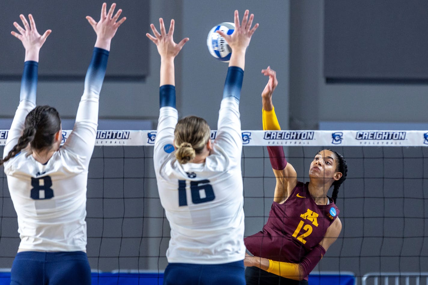 Minnesota's Taylor Landfair hit between Utah State's Kelsey Watson (8) and Adna Mehmedovic (16) during Friday's NCAA women's volleyball tournament first-round match in Omaha.