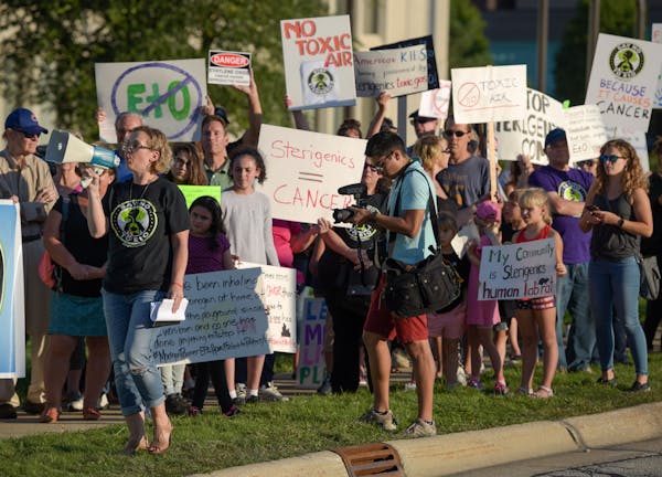 Protest organizer Neringa Zymancius of Darian leads the protesters in a chant in front of the Oak Brook headquarters of Sterigenics Friday, Sept. 14, 