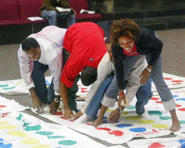 In this file photo, people play Twister in Edwardsville, Ill. Charles "Chuck" Foley, inventor of the iconic Twister game, died Monday, July 1, 2013, a