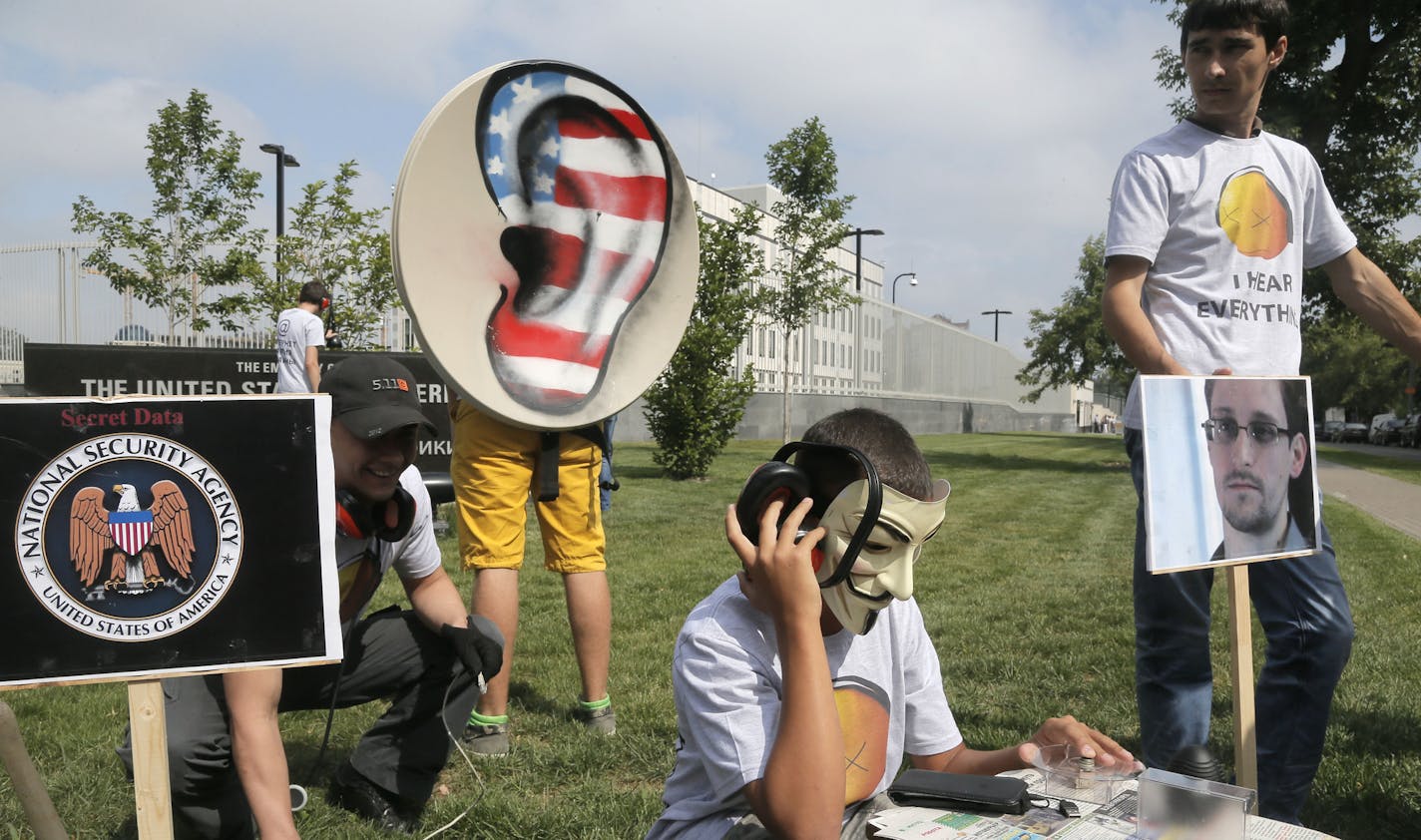 Activists of Ukraine's Internet party, one of them acting as a CIA agent making telephone taps, demand the American authorities stop the pursuit of National Security Agency leaker Edward Snowden at an action of protest near the US Embassy in Kiev, Ukraine, Thursday, June 27, 2013. (AP Photo/Efrem Lukatsky)