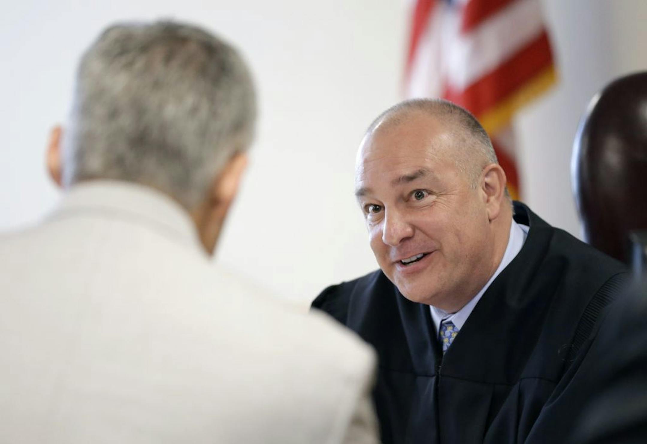 State District Judge Kelly W. Case, right, speaks with Montgomery County District Attorney Brett Ligon, left, Wednesday, Oct. 8, 2014, in Conroe, Texas. Minnesota Vikings running back Adrian Peterson made his first court appearance in Case's court Wednesday. The judge tentatively set a Dec. 1 trial date for Peterson on a charge of felony child abuse for using a wooden switch to discipline his 4-year-old son.