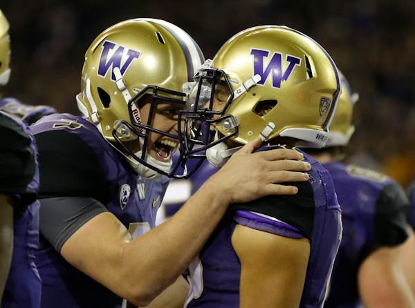 Washington quarterback Jake Browning, left, celebrates with wide receiver Aaron Fuller after Fuller caught a pass from Browning for a touchdown.