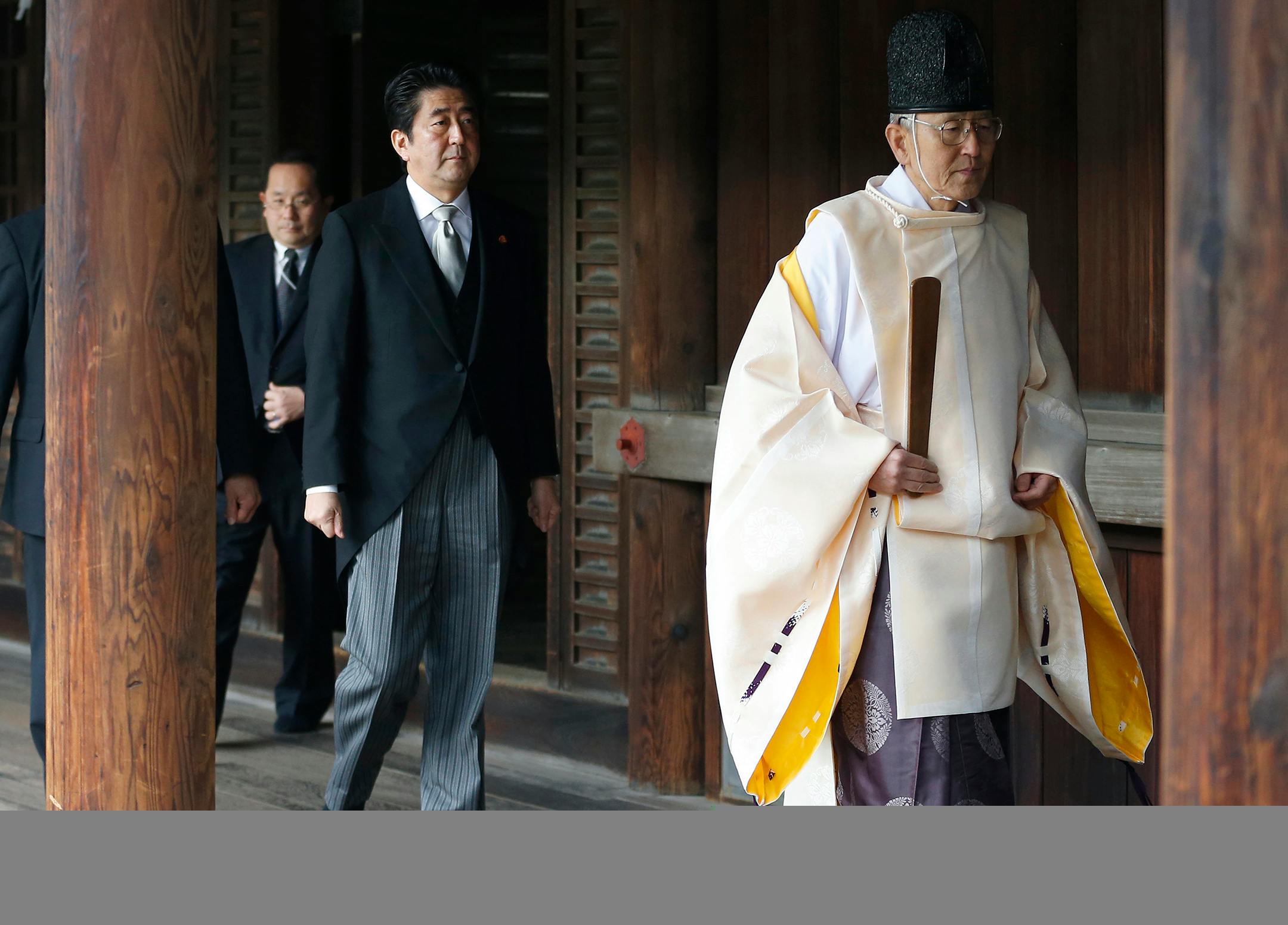 Japanese Prime Minister Shinzo Abe, second from right, follows a Shinto priest to pay respect for the war dead at Yasukuni Shrine in Tokyo Thursday, Dec. 26, 2013. Abe visited Yasukuni war shrine in a move sure to infuriate China and South Korea. The visit to the shrine, which honors 2.5 million war dead including convicted class A war criminals, appears to be a departure from Abe's "pragmatic" approach to foreign policy, in which he tried to avoid alienating neighboring countries. It was the fi