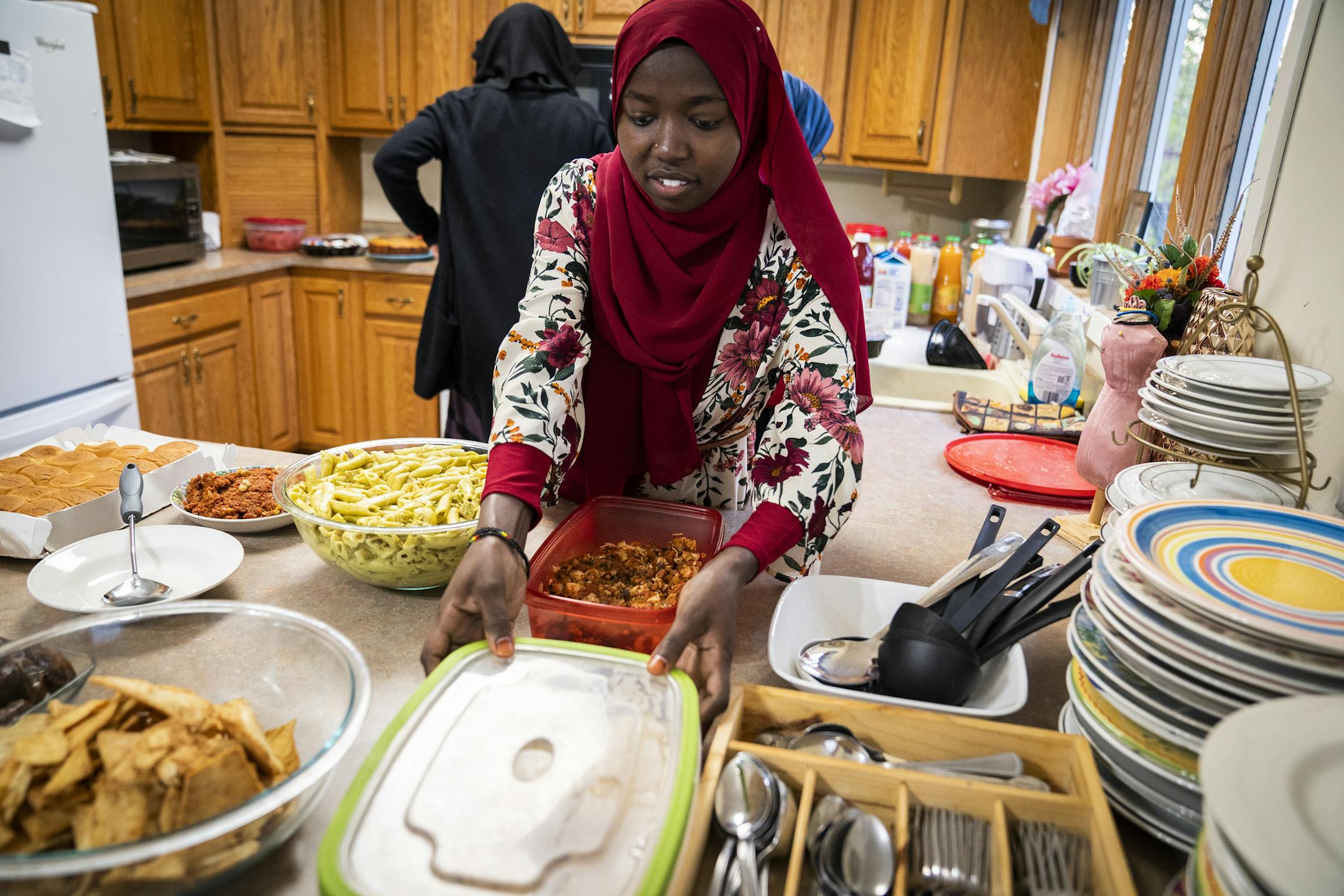 Emaan Soliman sets up the Iftar dinner at Club ICM. They encourage all those bringing food to the potluck Iftar dinners to bring reusable and washable containers. ] LEILA NAVIDI ¥ leila.navidi@startribune.com BACKGROUND INFORMATION: Iftar potluck dinner during Ramadan at Club ICM in Fridley on Tuesday, May 14, 2019. For a story on initiatives taken by different Muslim organizations to ensure minimum wastage of food and minimal trash waste during Ramadan and Iftar get togethers.