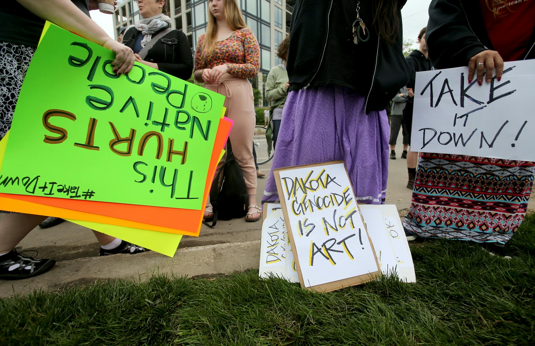 A controversial new sculpture at the Walker Art Center that prompted an outcry among Minnesota's American Indian communities will be dismantled, the director said Saturday. Here, protestors with signs outside the Walker Sculpture Garden Saturday, May 27, 2017, in Minneapolis, MN.
