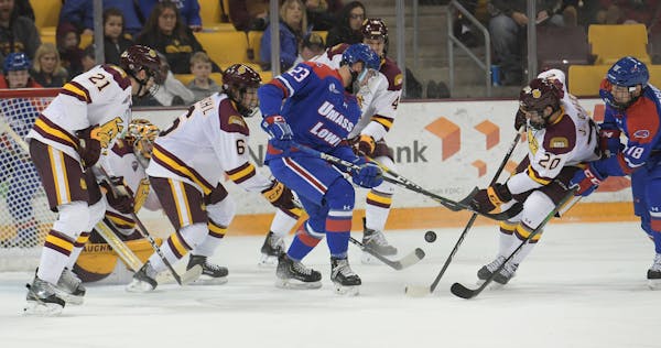 Minnesota Duluth forward Jackson Cates battles for the puck in the first period against UMass Lowell's Zach Kaier