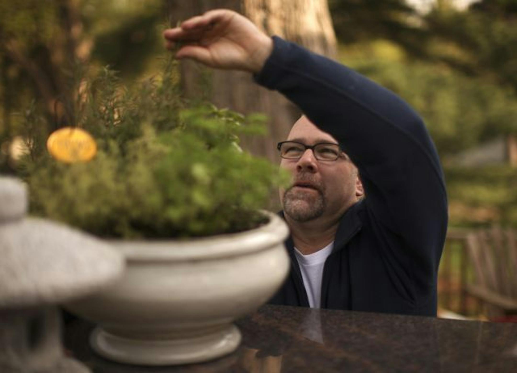 Thomas DeGree likes the scents he cultivates in his garden. This pot in the outdoor kitchen contains thyme and other herbs handy for cooking.