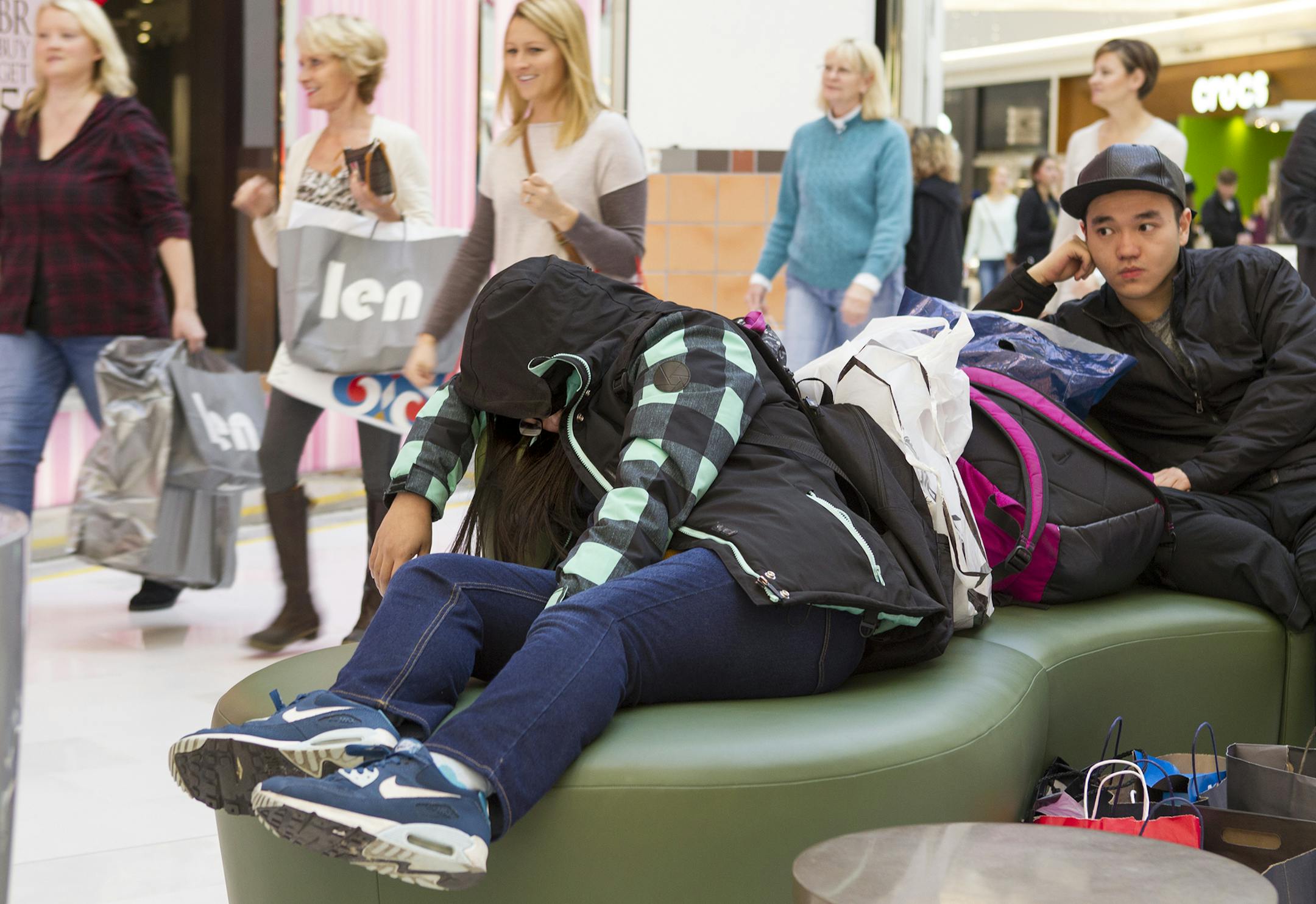 Sue Yuan, left, takes a nap as she and fellow University of Minnesota student Michael Zhang wait for their friends at the Mall of America in Bloomington November 27, 2015. The group had arrived the night before, on 6pm Thanksgiving Day, and shopped all night and into Black Friday morning. Yuan said this was her third nap. (Courtney Perry/Special to the Star Tribune)