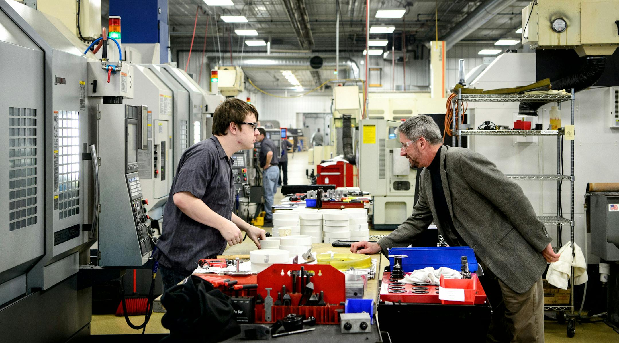 James Sieben, president of Nova-Tech Engineering, right, talked with CNC operator Ethan Wilkins in the Nova-Tech production facility in the MinnWest Technology Center, Willmar. ] GLEN STUBBE * gstubbe@startribune.com Monday, November 23, 2015