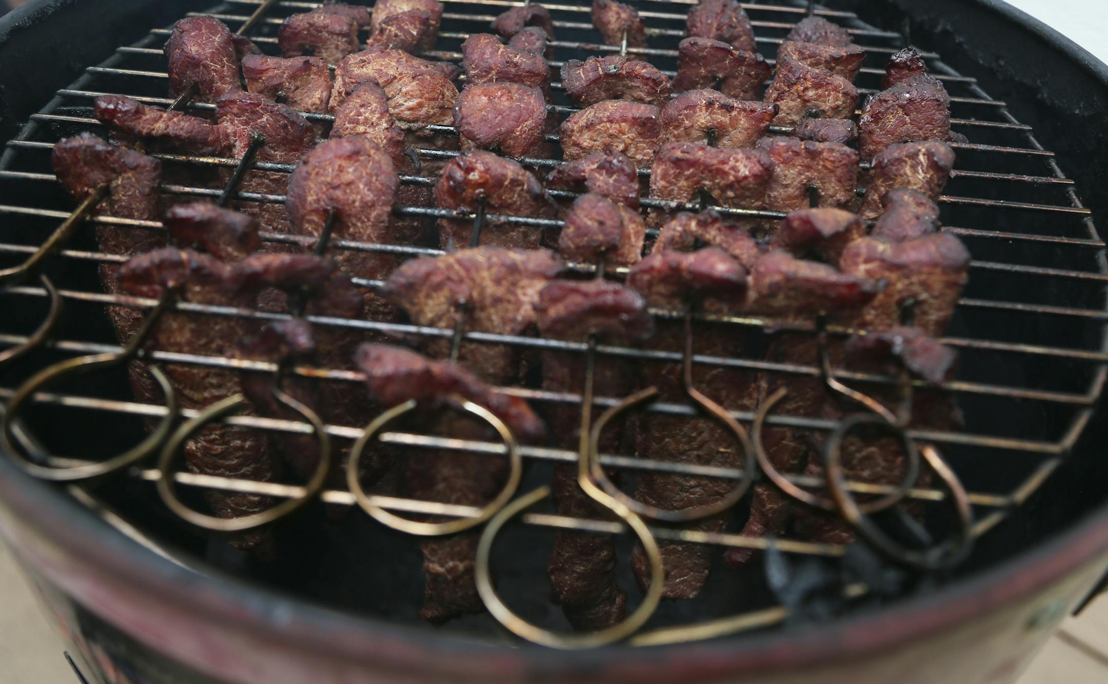Beef jerky slowly cures during Smokapalooza 2013, on the deck of the Pupel family residence Saturday, May 26, 2013 in Plymouth, MN.](DAVID JOLES/STARTRIBUNE) djoles@startribune How do you learn the intricacies and nuances of user a smoker? By having lots and lots of experiments going on at one time. How do you do that? By gathering 10 families, smokers and grills at the ready, for Smokapalooza. Everyone learns, by successes and failures, and they eat really well. More than 200 pounds a meat was