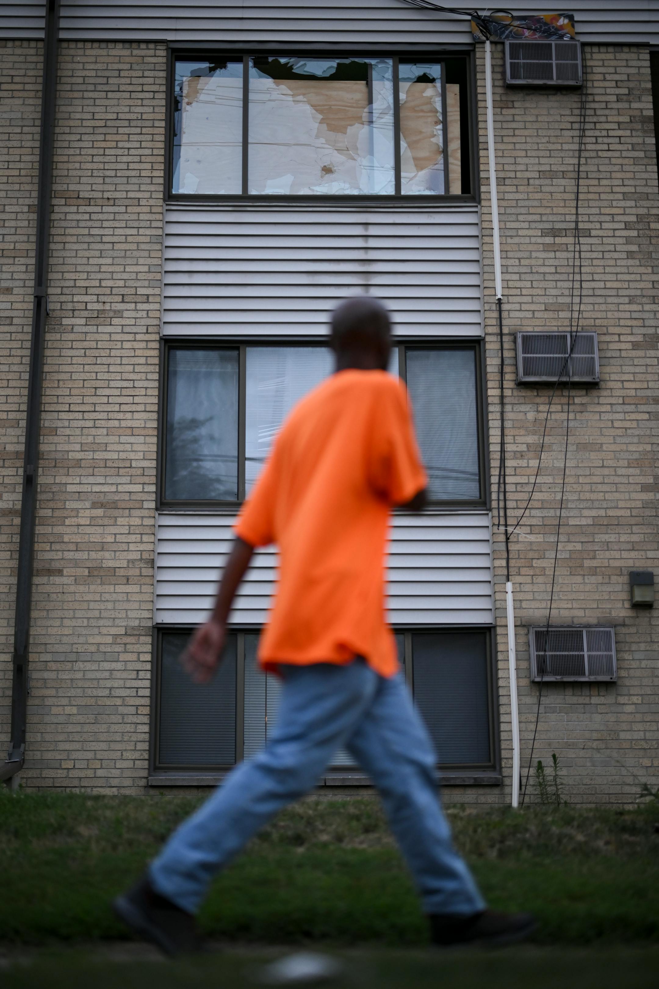 Black Lives Matter activist Trahern Crews walked past a broken window during a vigil Thursday for 20-year old Andrew Tekle Sundberg.