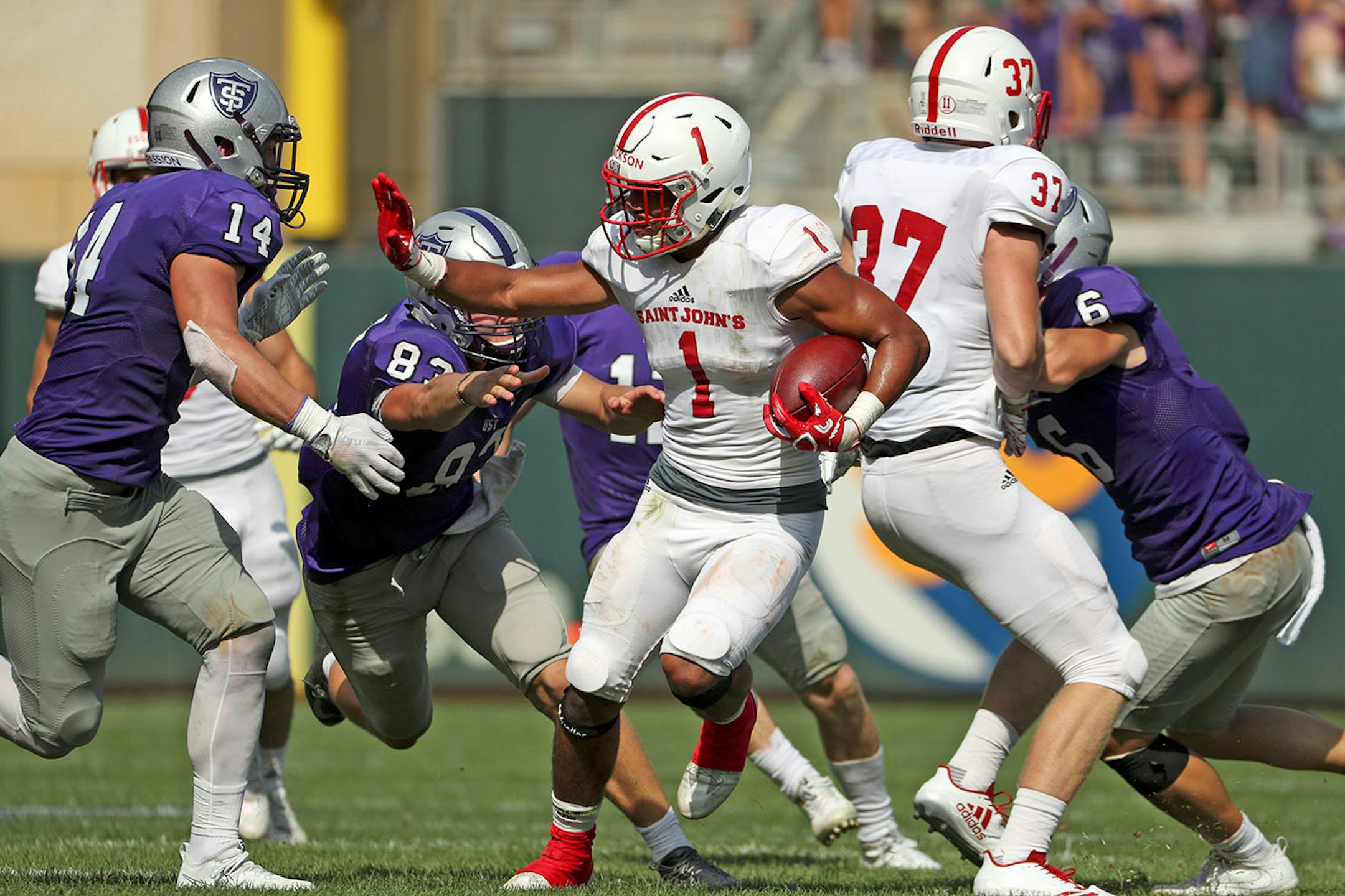 St. John's University wide receiver Joey Eckhoff (1) reached out to block University of St. Thomas linebacker Blake Weber (14) as he ran the ball in the first half.