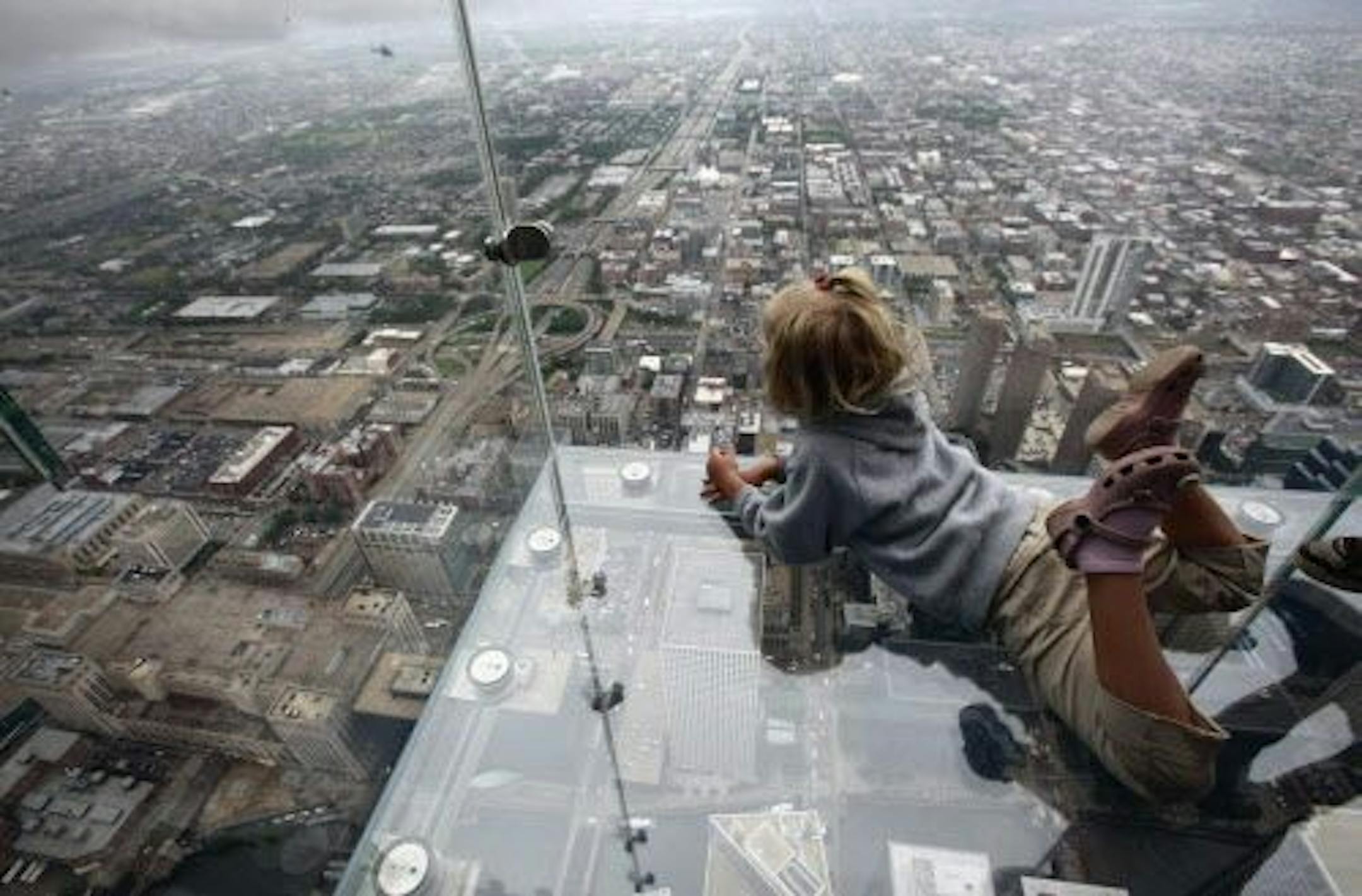 This 2009 file photo shows Anna Kane, 5, looking down from the "The Ledge," at Chicago's Willis Tower.