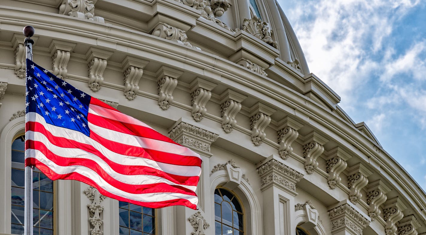 Washington DC Capitol dome detail with waving american flag