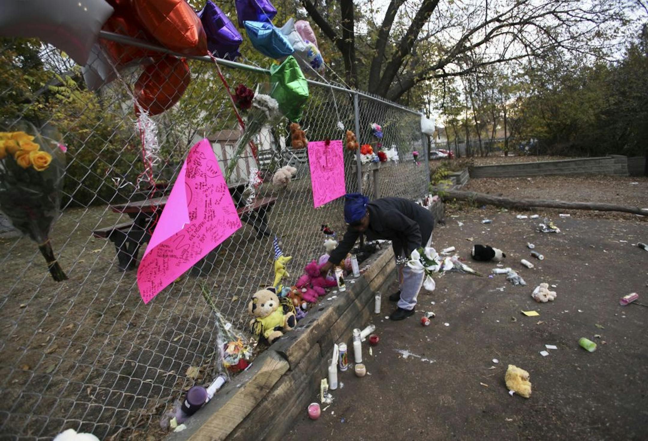 A friend cleaned up broken glass and repositioned flowers and stuffed animals at a memorial near where Naressa Turner was killed Sunday afternoon in St. Paul's Dayton's Bluff neighborhood.