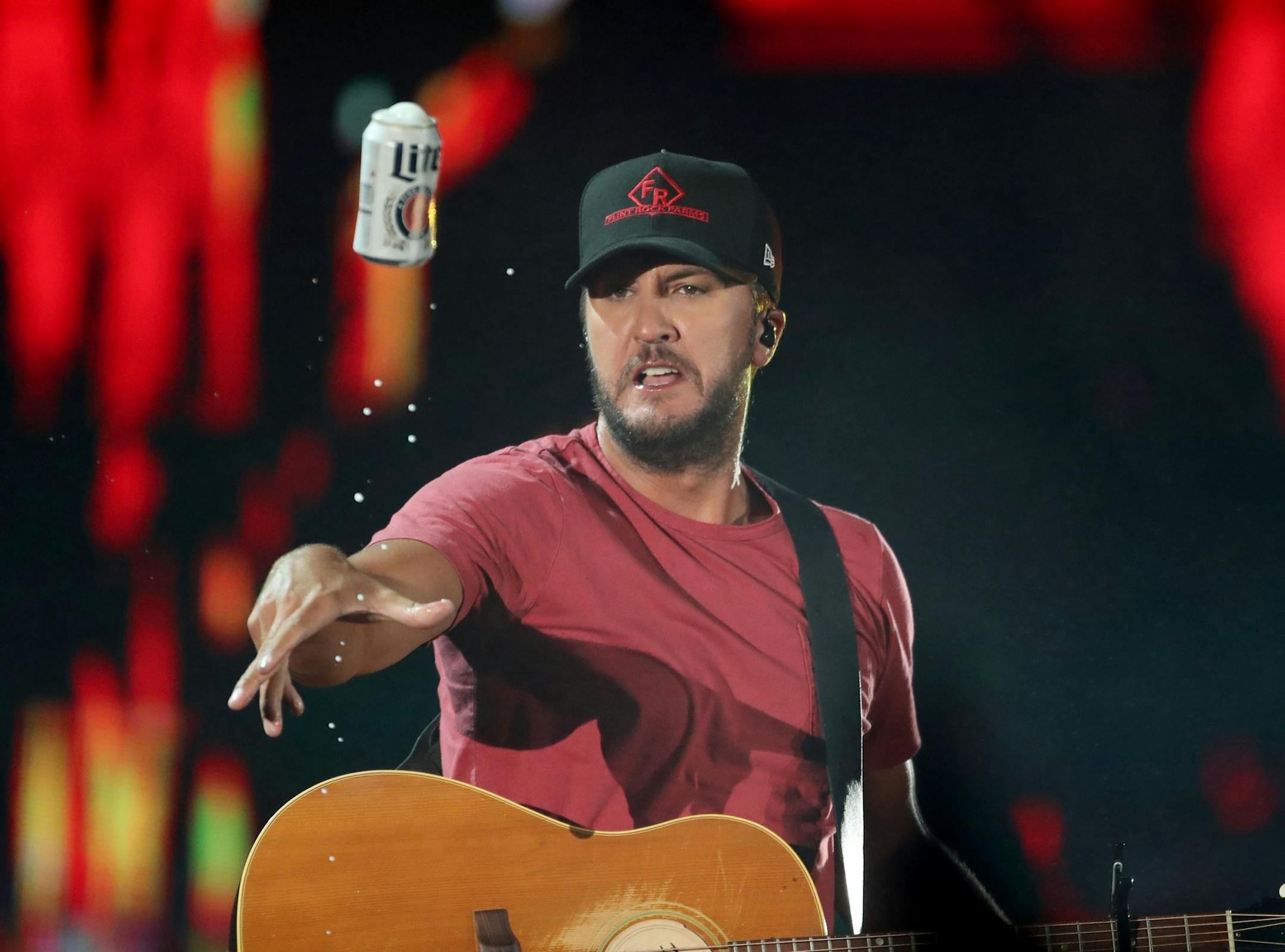 After taking a sip, headliner Luke Bryan tossed a cold one into the crowd while performing Saturday, July 21, 2018, at Target Field in Minneapolis, MN.