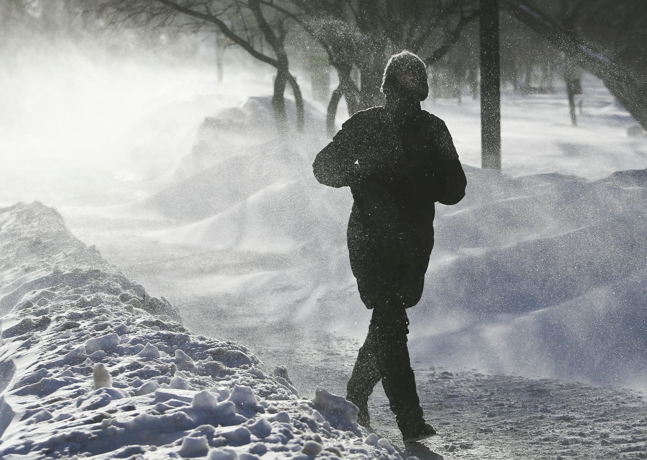 Uve Hamilton of St. Paul was visiting her daughter who lives near Lake Harriet when she decided to tak a walk along the lake in blizzard-like conditions Wednesday Jan. 22, 2014, in Minneapolis, MN. "I don't know how far I'll get," she said. At one point blowing snow was so intense she couldn't see the camera she had brought strapped around her coat and she thought she had dropped it and went back before she realized it was on her.](DAVID JOLES/STARTRIBUNE) djoles@startribune.com High winds coupl