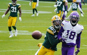 Minnesota Vikings wide receiver Justin Jefferson (18) was unable to complete a touchdown pass as Green Bay Packers cornerback Jaire Alexander (23) def