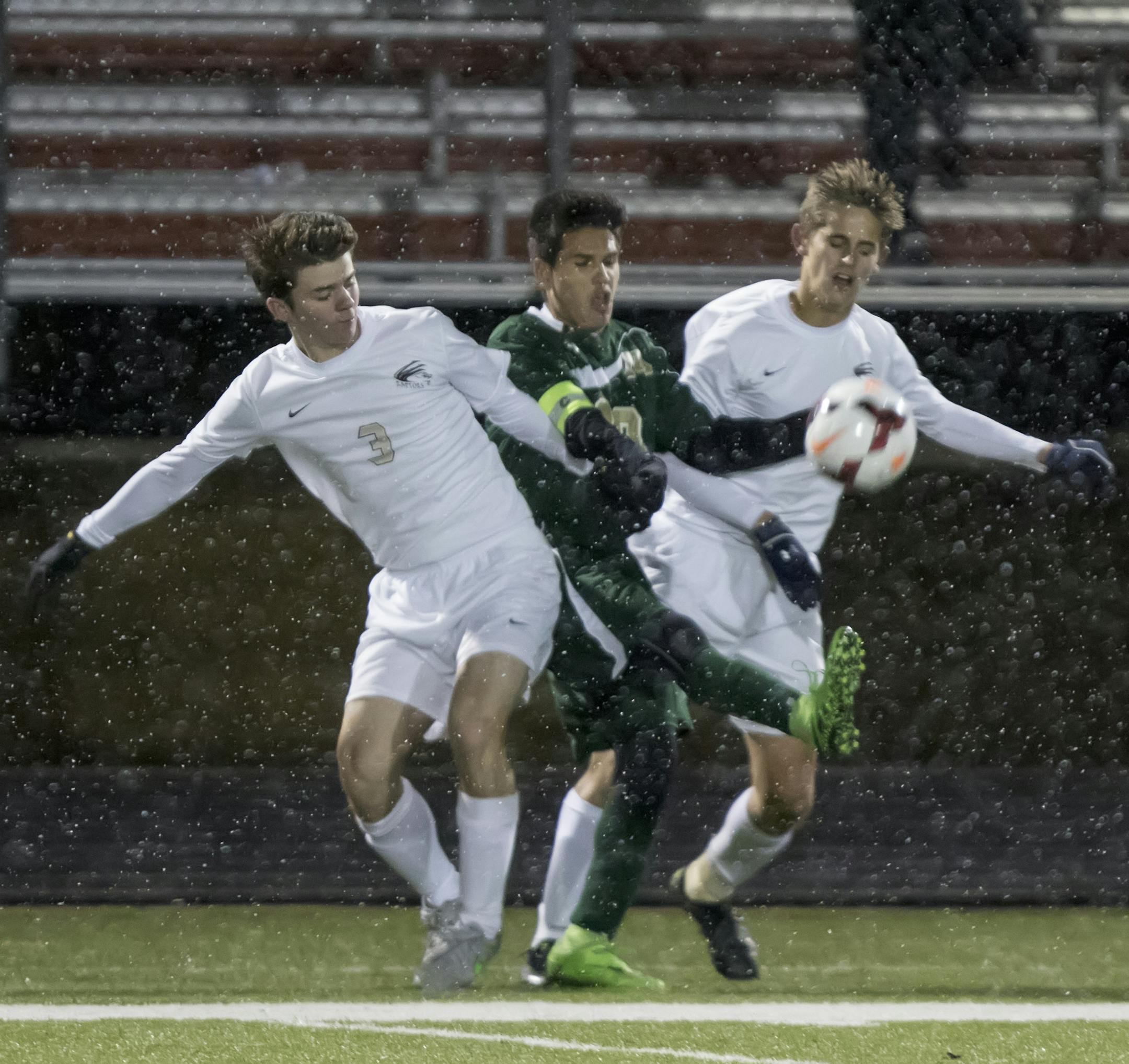 East Ridge defender Jake Boerjan (3) and East Ridge defender Brock Sullivan (14) try to take the ball away from Rochester Mayo forward Jonathan Loera (13) as the East Ridge Raptors faced the Rochester Mayo Spartans in the 2015 MSHSL Boys' soccer playoffs. ] MATT BLEWETT ï matt@mattebphoto.com - October 28, 2015, Farmington, MN, East Ridge Raptors, Rochester Mayo Spartans, Prep Soccer, East Ridge Raptors vs Rochester Mayo Spartans